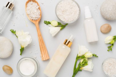 Renkli arka planda spa ürünleri ve çiçeklerle düz yatıyordu