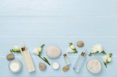 Tahta arka planda kaplıca ürünleri ve çiçeklerle yatıyordu