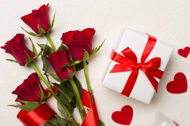 Beton arka planda hediye kutusu olan kırmızı gül çiçekleri, üst, manzara. Sevgililer Günü konsepti