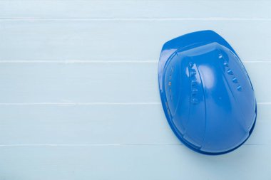 Ahşap arka planda mavi miğfer, üst manzara.