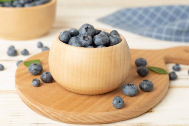 ahşap masa üzerinde taze yaban mersini ile kase