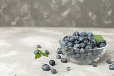 Beton arka planda taze yaban mersinli kase