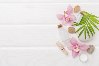 Orkideli kompozisyon, ahşap arka planda spa ürünleri, üst görünüm