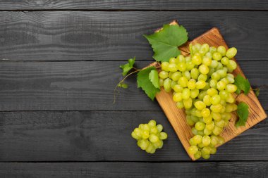 Ahşap zemin üzerinde taze yeşil üzüm, üst görünüm