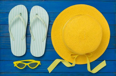 Ahşap arka planda renkli plaj aksesuarları olan düz bir yer. Tatil kavramı