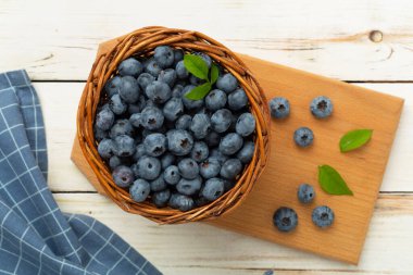 Ahşap arka planda taze yaban mersinli kase, üst manzara.
