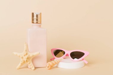 Masada renk arkaplanına karşı yaz dekorlu güneş kremi