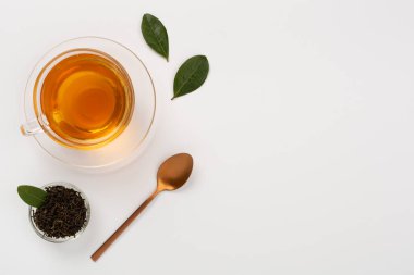 Beton arka planda kuru ve taze yapraklı bir fincan çay, üst manzara.