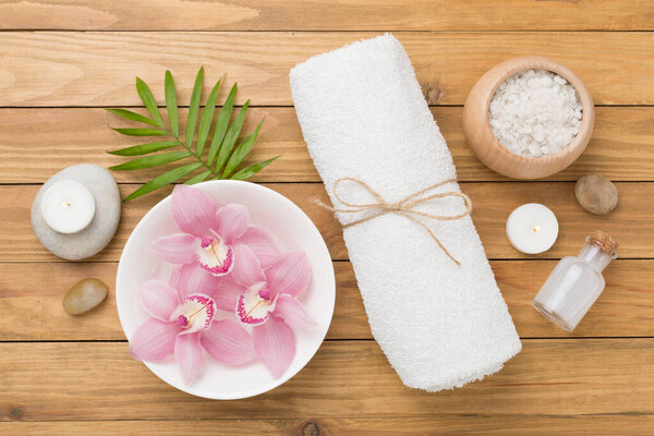 Composition with orchids and massage stones on wooden background, top view