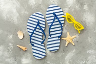 Beton zemin üzerinde çizgili mavi parmak arası terlikler, üst görünüm