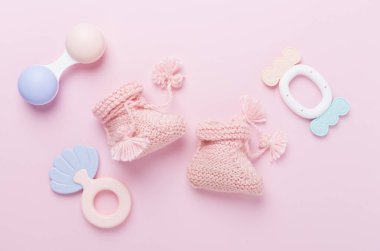 Renkli arka planda pembe bebek paçaları ve tıkırtılar, üst görünüm