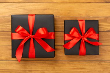 Ahşap arka planda siyah hediye kutuları, üst manzara. Kara Cuma konsepti