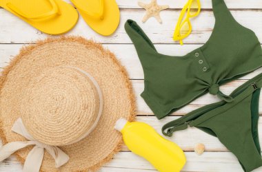 Ahşap arka planda renkli plaj aksesuarları olan düz bir yer. Tatil kavramı