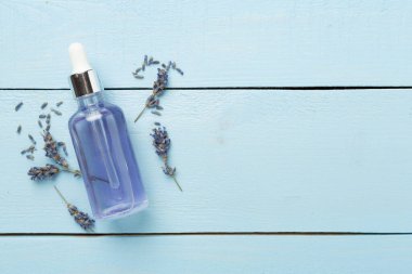 Ahşap zemin üzerinde lavanta özü olan şişe, üst görünüm.
