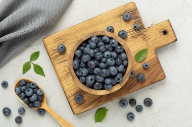 Beton arka planda taze yaban mersinli kase, üst manzara.