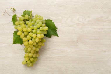 Ahşap zemin üzerinde taze yeşil üzüm, üst görünüm