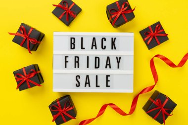 Kara Cuma indirimli ışık kutusu ve renk arkaplan üzerinde hediye kutusu, üst görünüm