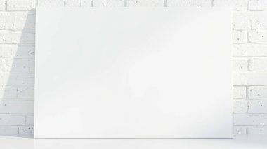 Boş beyaz bir tuval, bembeyaz bir tuğla duvara yaslanarak minimalist ve temiz bir estetik yaratıyor. Bu boş tuval sanat ve tasarım sunumları için mükemmel bir şablon sunuyor. Beyaz yüzey ve desenli tuğla arka plan bir mod sağlar