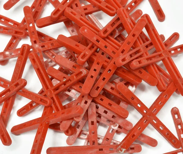 Seramik fayansların düzgün konumu ve dengeli uzayın oluşumu için kullanılan kırmızı kiremit haçları yığını 