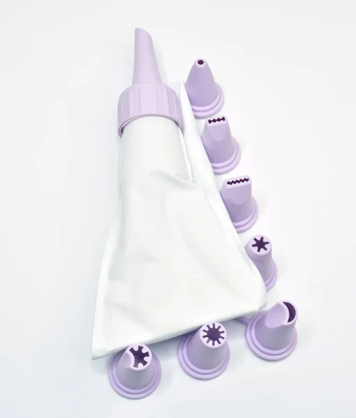 白い背景にパイプ袋とノズルを飾るケーキのセット — ストック写真