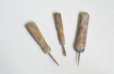 Gri arkaplanda delikler açmak ve dikiş dikmek için eski araçlar