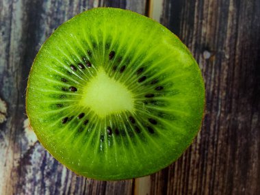 Yarım kivi. Yukarıdan bak. Tahta bir masada tropik yeşil meyve. Kapatın. Makro fotoğrafçılık 