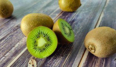 Biraz kivi ve iki buçuk. Tahta bir masada tropik yeşil meyve. Kapat. 