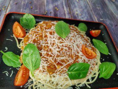 Et ve domates soslu makarna. Spagetti bolonez, domates ve ıspanak yaprakları. Peynirli parmesan. 