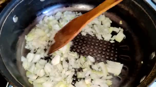 シェフは野菜油でフライパンで揚げたタマネギを攪拌します — ストック動画