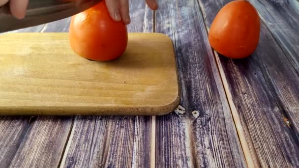 木の板の上で柿を１つ半分に切る — ストック動画