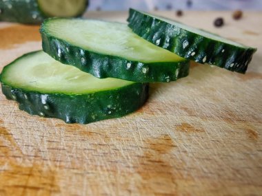 Fresh cucumber slices on a wooden board. Close-up
