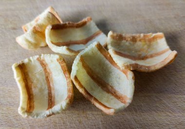 Bacon. Several slices of fried bacon on a wooden board. Close-up. Finished product