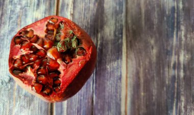 Moldy pomegranate fruit on a wooden table. Close-up