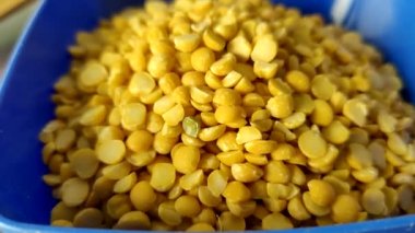 Split peas close-up in a blue bowl on a wooden table.  Shooting from above