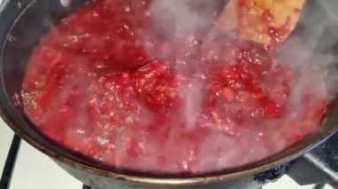 The chef stirs the borscht saute.  Cooking red borscht