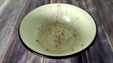 Raw buckwheat from above falls into a white metal bowl