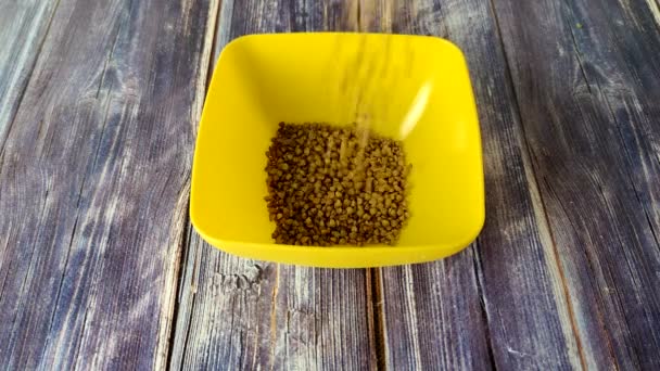 Raw Buckwheat Poured Yellow Plastic Bowl — Stock video