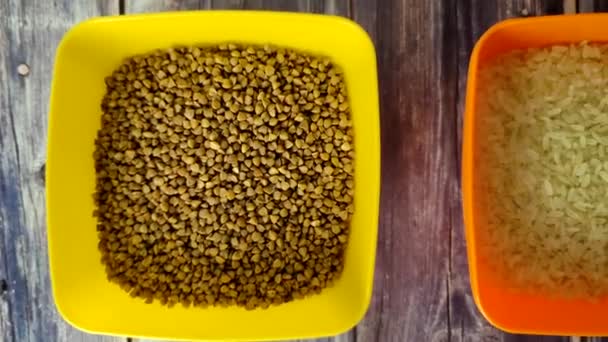 Raw Rice Yellow Split Peas Buckwheat Plastic Bowls Wooden Table — Stock video