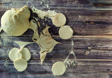 Ahşap bir masanın üzerinde hamur çemberleri. Patates köftesi. Yukarıdan görüntüle 