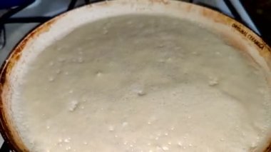 Siyah bir tavada kızarmış krep hazırlıyorum. Krep pişiriyorum. Yukarıdan görüntüle