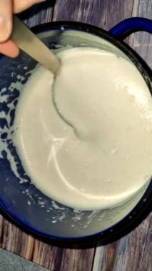 Demonstration of the finished dough for pancakes using a ladle.  pancakes