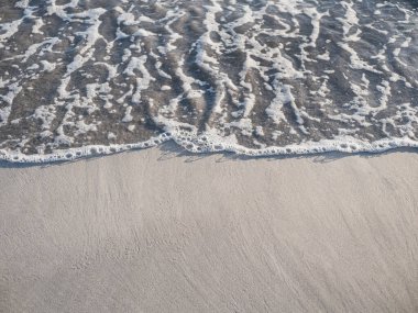 Sahili süpüren küçük dalga kopya alanı ile arkaplanı kapat