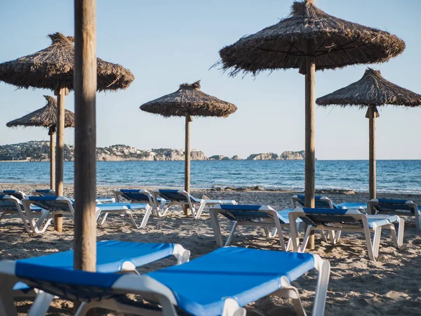 Sandy Beach Blue Sunbeds Straw Umbrellas Sea Background Mediterranean Beach — Stock Photo, Image