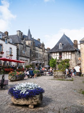 Rochefort-en-Terre, Fransa: 5 Ağustos 2024: Rochefort-en-Terre, Fransa 'daki Place du Puits' te oturan turistler