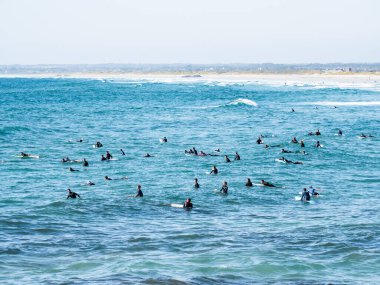 La Torche plajı, Fransa; 9 Ağustos 2024: La Torche sahilinde dalgaları bekleyen bir sürü sörfçü