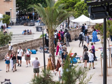 Palma de Mallorca, İspanya; 17 Eylül 2024: Palma de Mallorca Katedrali 'nde açık hava satıcılarıyla uğraşan bir grup insanla kalabalık bir şehir caddesi.
