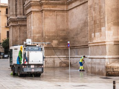 Palma de Mallorca, İspanya; 9 Ekim 2024: Emaya temizlik servisi aracı ve Palma de Mallorca Katedrali 'nin yanındaki operatör