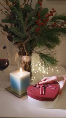 Yakından yanan mum. Arka planda süslenmiş noel ağacı. Kış tatili konsepti. Evde yeni yılı kutluyoruz. Ağır çekim. Dikey video