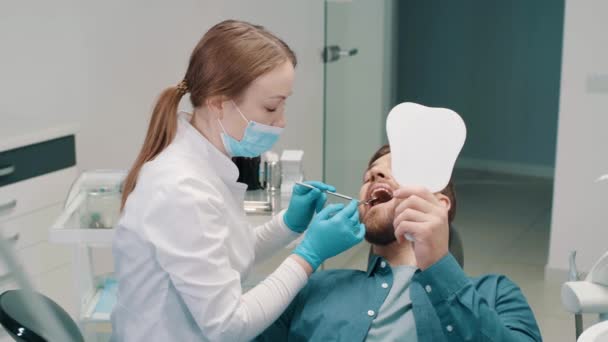 Chica Dentista Trata Los Dientes Odontología Paciente Con Espejo Dental — Vídeos de Stock