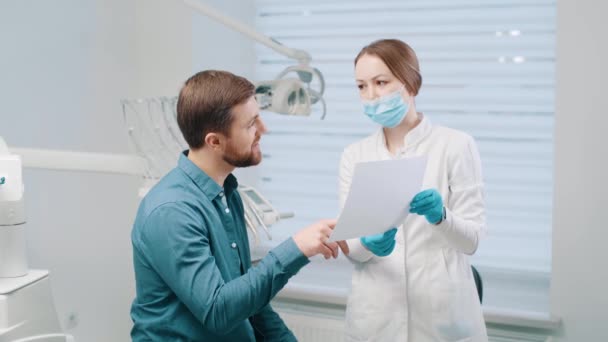 女性医師は 患者と歯科修復とリハビリテーションの計画を議論します — ストック動画